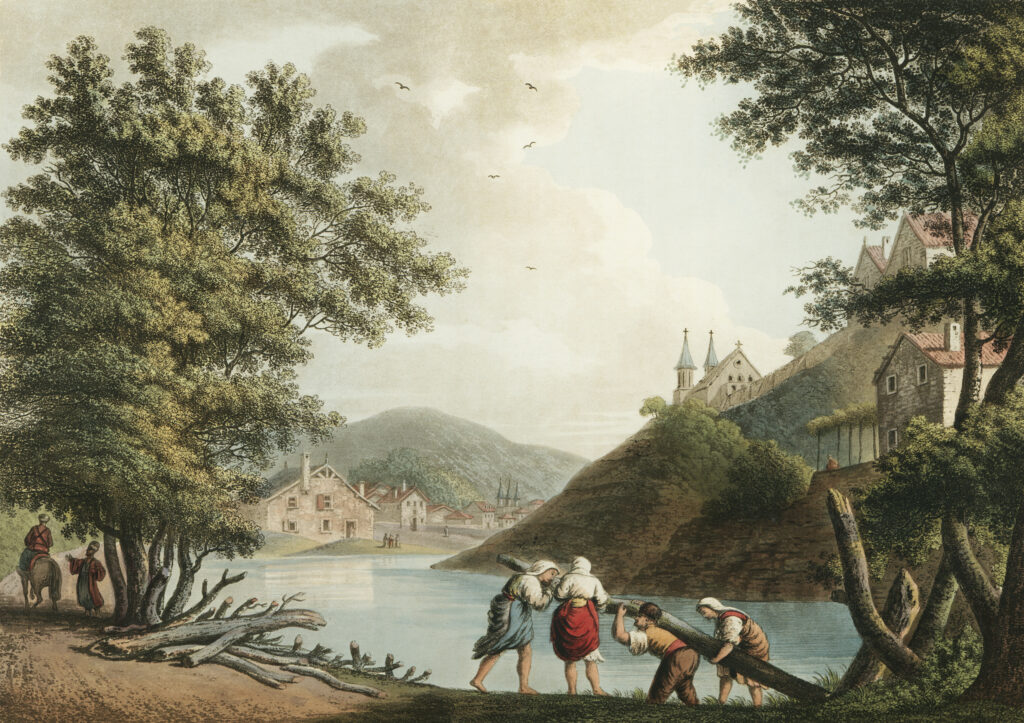 Hand-coloured landscape print from Luigi Mayer's "Views in the Ottoman Dominions." A calm river winds past a small stone village, with a hilltop church of two spires rising on the right. In the foreground, villagers carry a felled tree trunk along the bank while a rider and a companion pass beneath tall trees on the left.